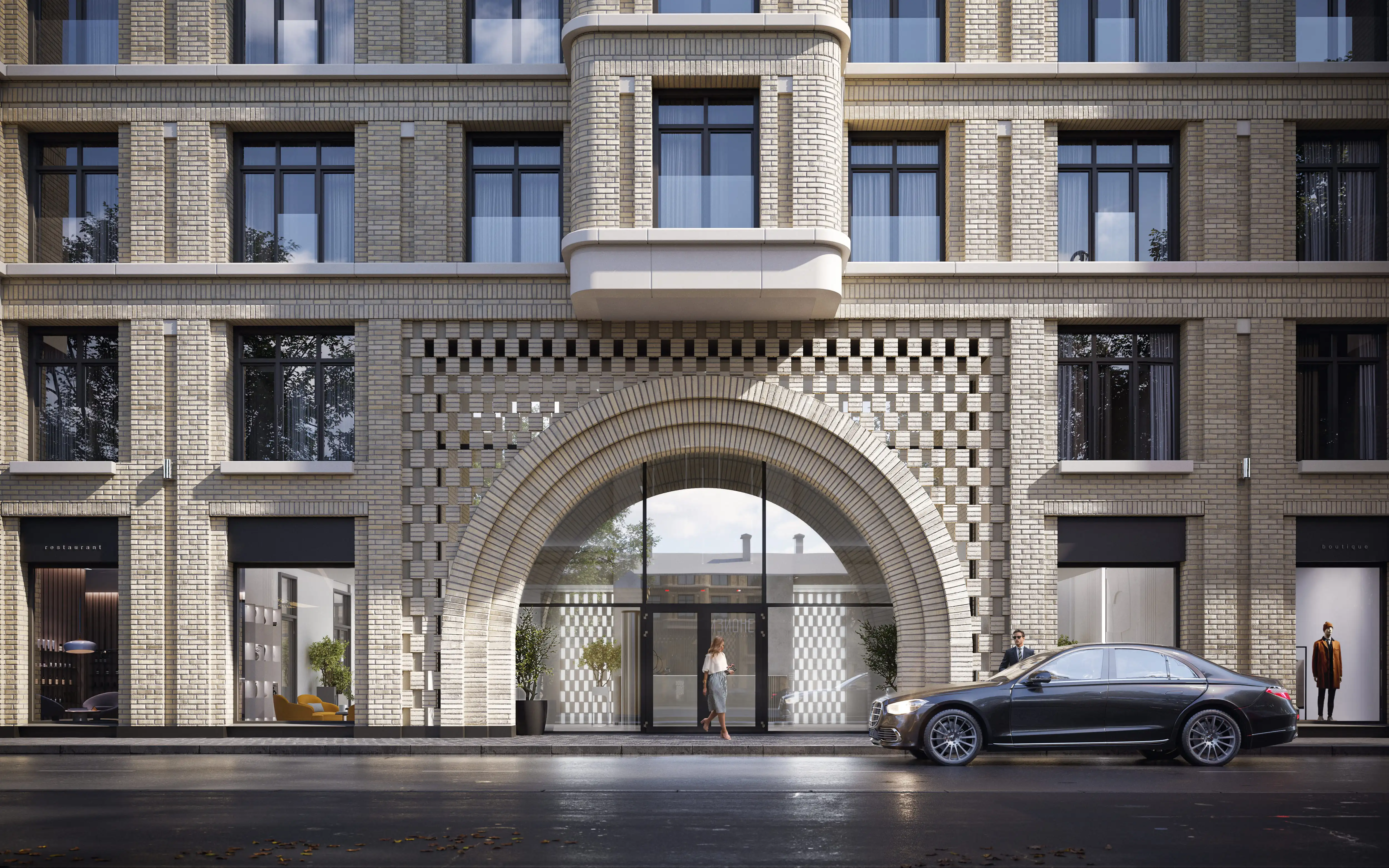 Элегантный фасад клубного дома «Визионер» с арочным входом и декоративными элементами из светлого кирпича, современная архитектура с премиальной отделкой